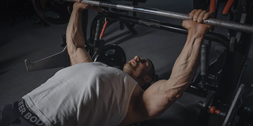 Member performing a heavy barbell bench press