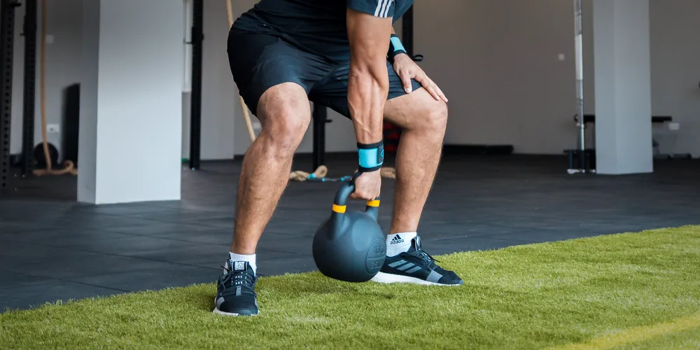 Member performing a kettlebell deadlift with focused form